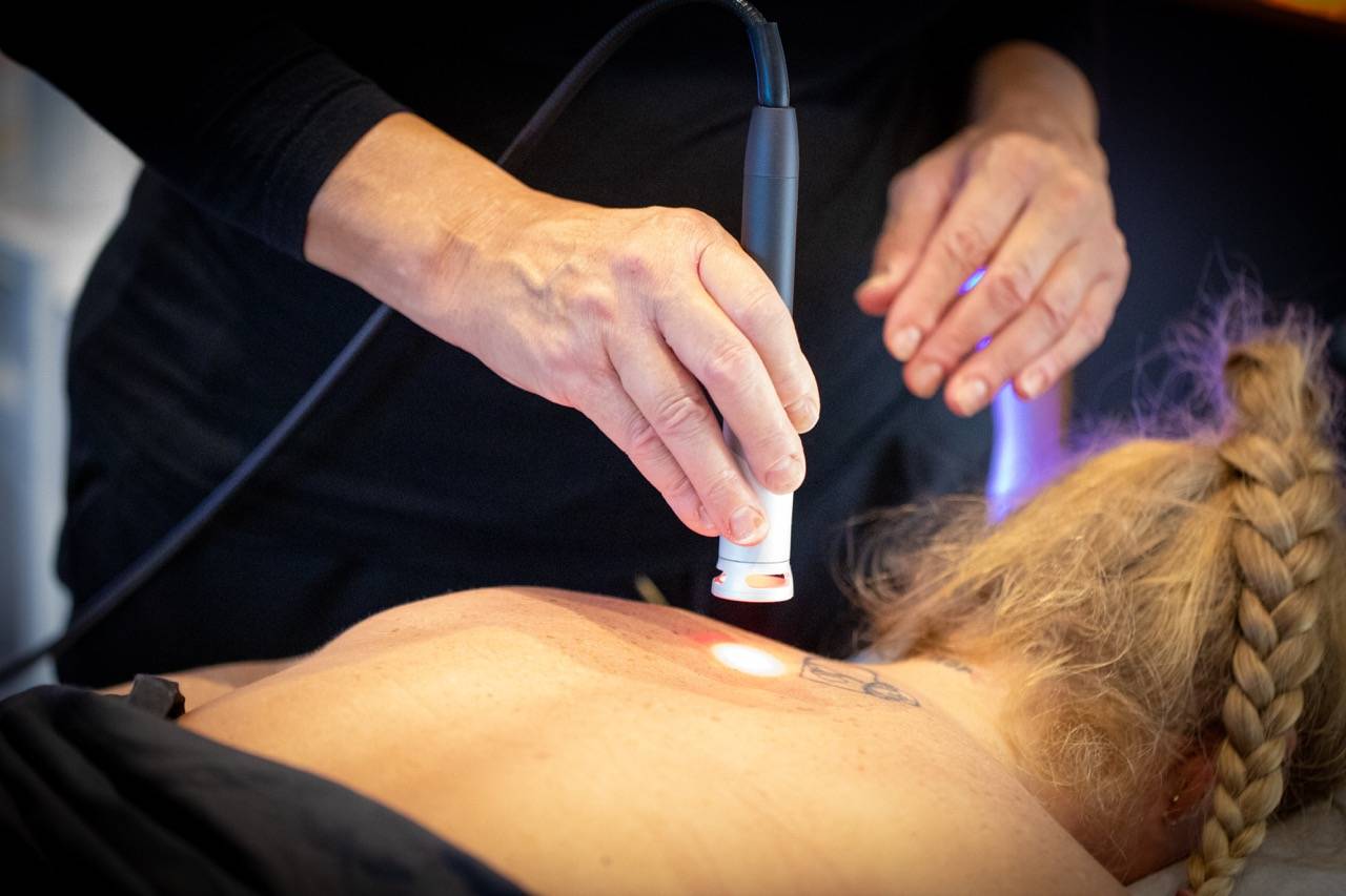 Lene Kryger laver Laserterapi i Næstved på kvindes ryg.