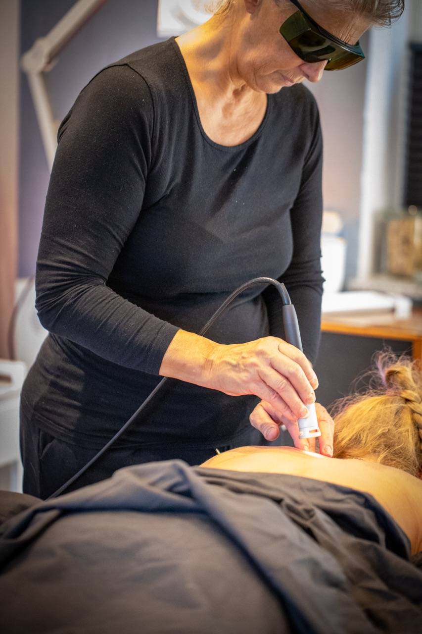 Lene Kryger med laser. Behandler ryg på kvinde. Næstvd, Sydsjælland